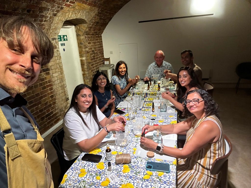 Guests sharing a hands-on candle-making workshop with STANZA Artigiana around a lemon-patterned table