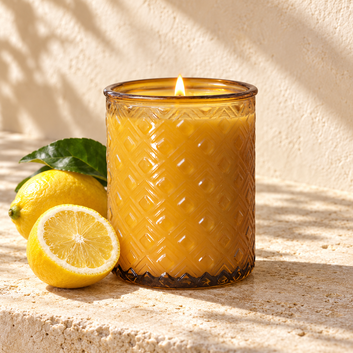Sorrento yellow glass candle with lemon on a pale stone surface